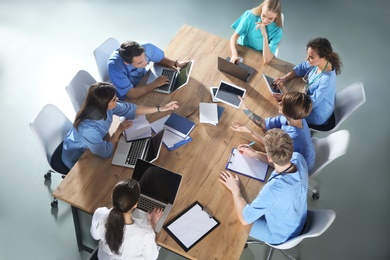 Photo of Group of medical students with gadgets in college, top view