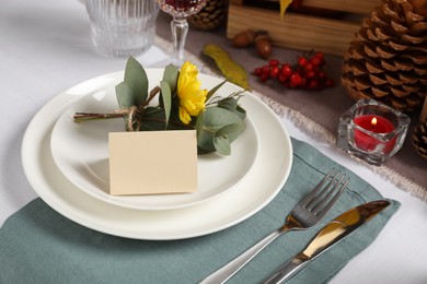 Beautiful autumn place setting with blank card and decor on table