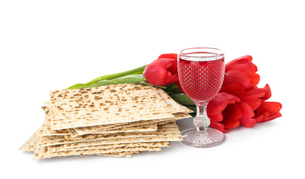 Photo of Passover matzos, glass of wine and flowers on white background. Pesach celebration