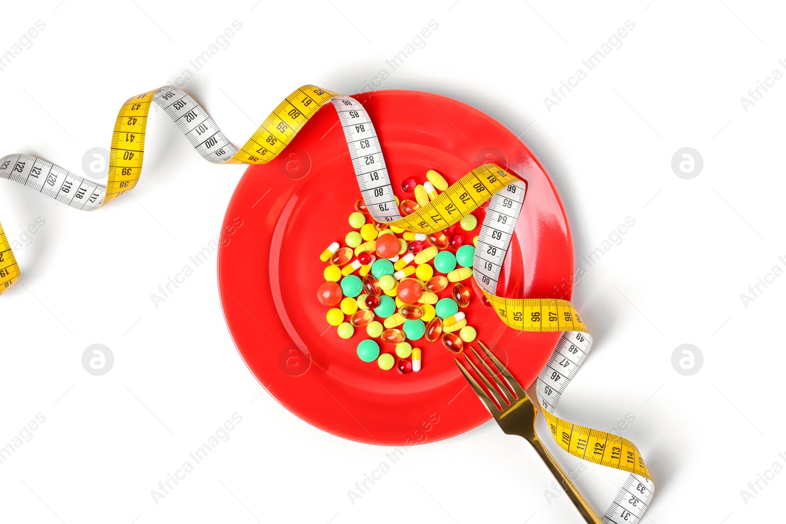 Photo of Plate with weight loss pills, fork and measuring tape on white background, top view