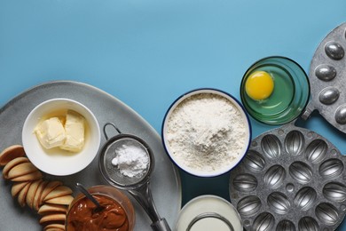 Baking mold and ingredients for walnut shaped cookies on light blue table, flat lay. Space for text