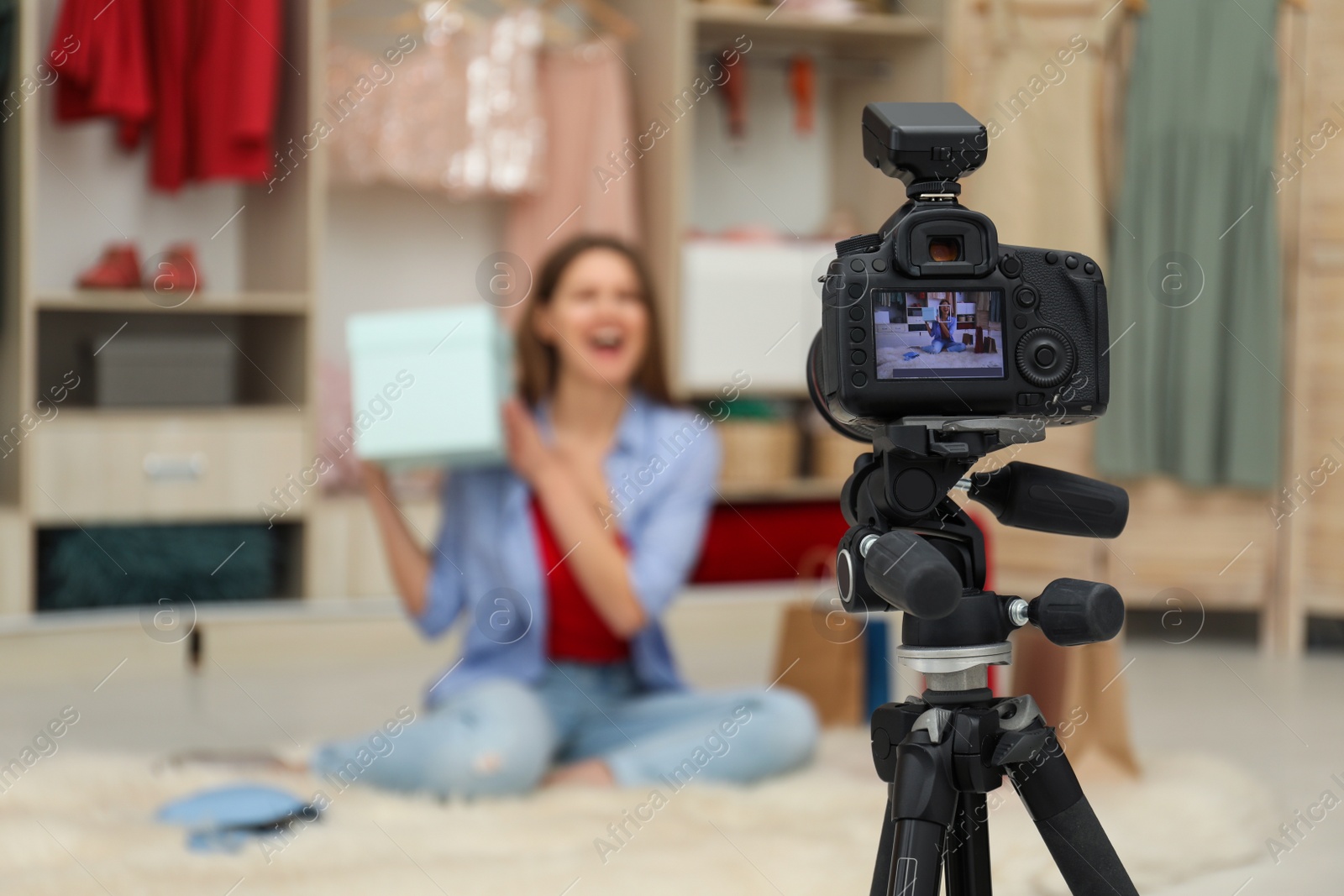 Photo of Fashion blogger recording new video in room, focus on camera