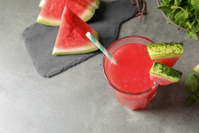 Photo of Summer watermelon drink in glass and sliced fruit on table