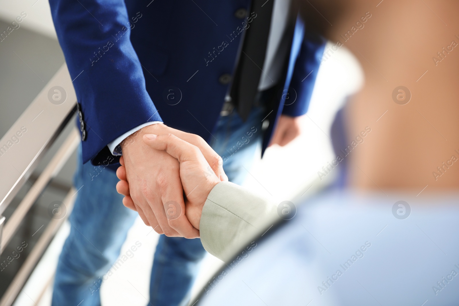 Photo of Business partners shaking hands after meeting, closeup