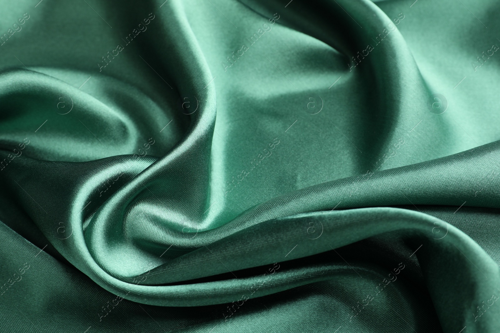 Photo of Crumpled green silk fabric as background, closeup