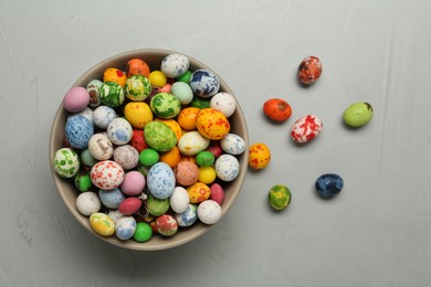 Photo of Ceramic bowl with delicious candies on grey table, flat lay. Cooking utensil
