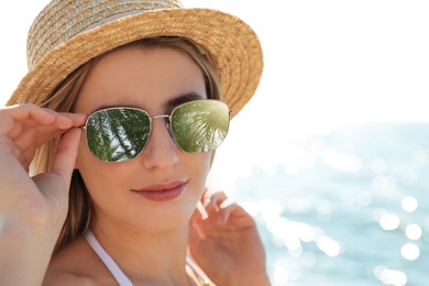 Image of Happy woman on vacation. Green palm leaves mirroring in her sunglasses