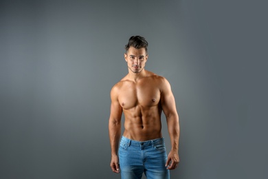 Photo of Shirtless young man in stylish jeans on grey background