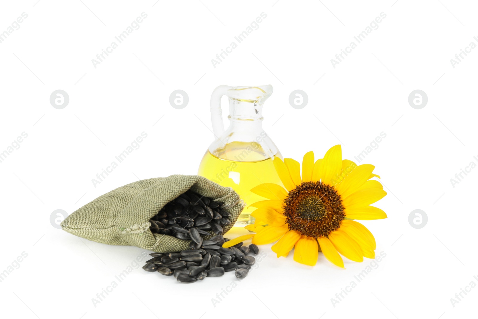 Photo of Sunflower, jug of oil and seeds on white background