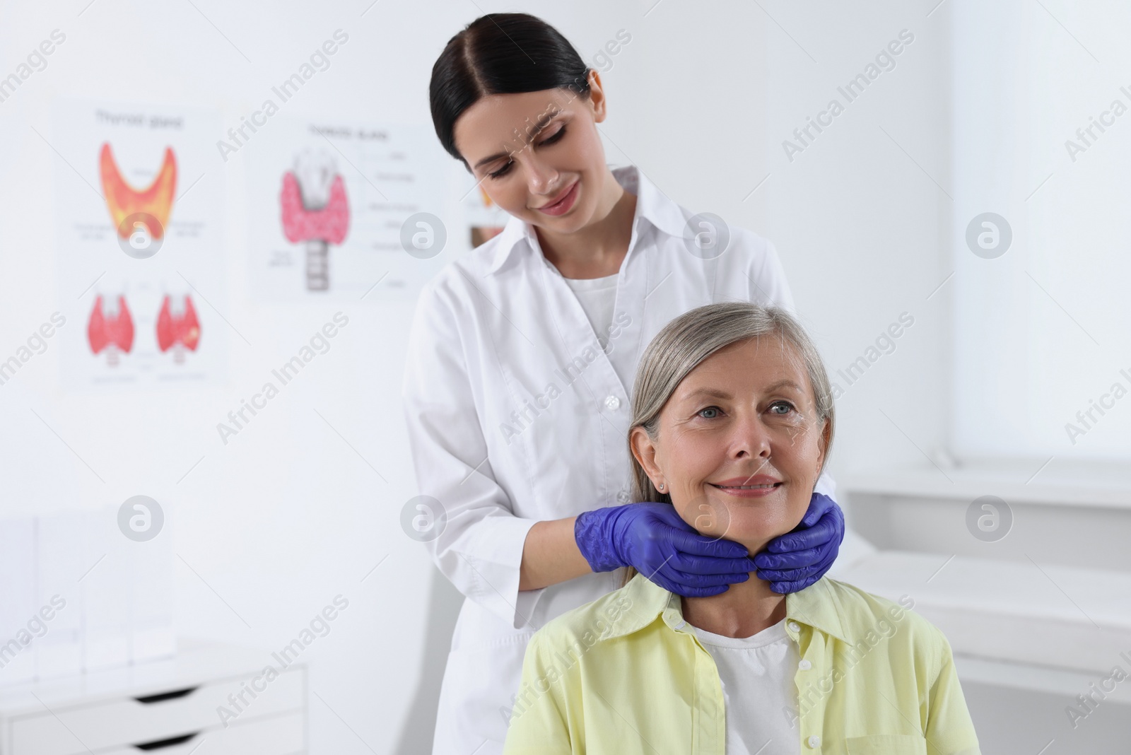 Photo of Endocrinologist examining thyroid gland of patient at hospital