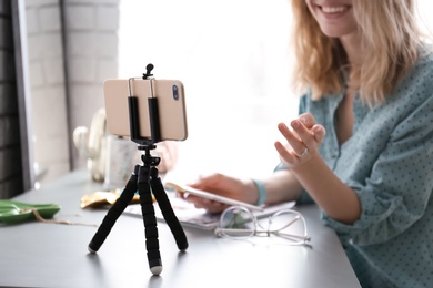 Photo of Female blogger recording video at table