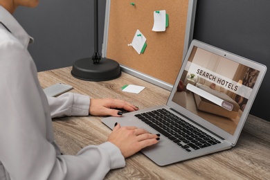 Image of Woman searching hotel using laptop at table, closeup. Booking online service