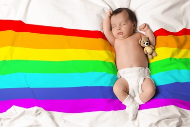 Image of National rainbow baby day. Cute child sleeping on blanket with colorful pattern, top view