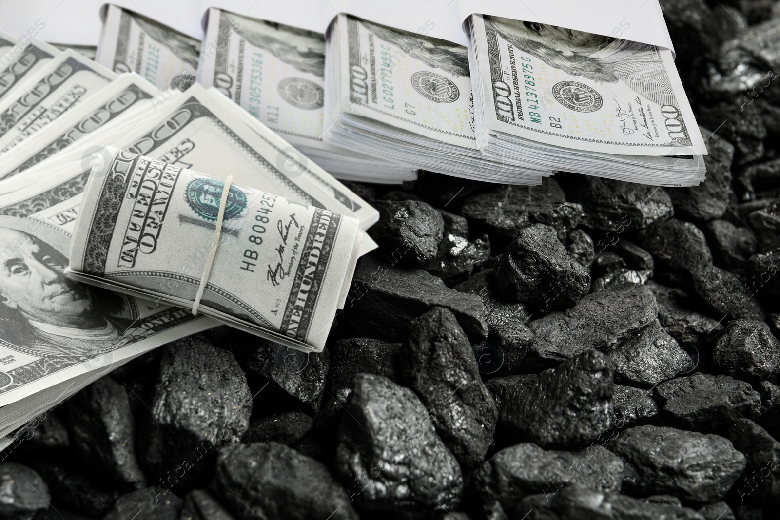 Image of Dollar banknotes on pieces of coal, closeup. Resource price