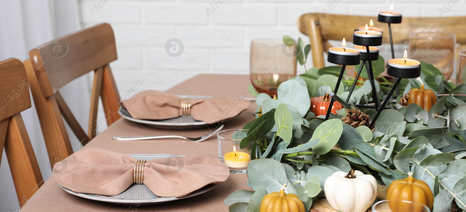 Image of Autumn table setting with eucalyptus branches and pumpkins indoors. Banner design