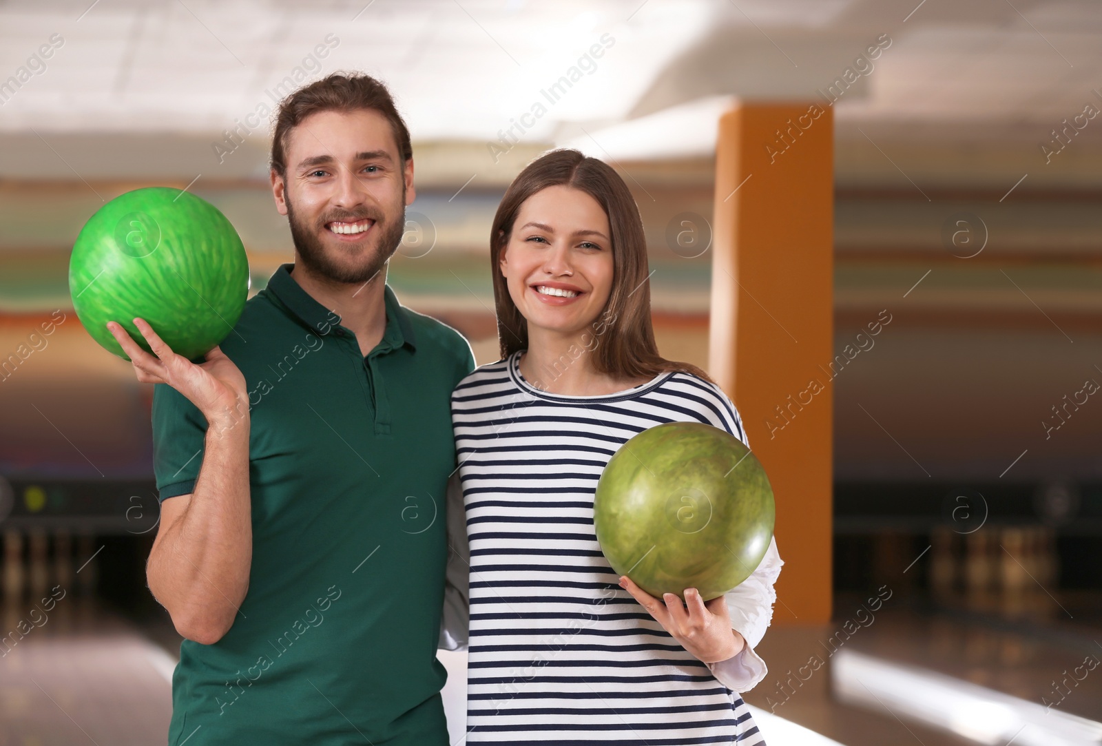 Photo of Young couple with balls in bowling club