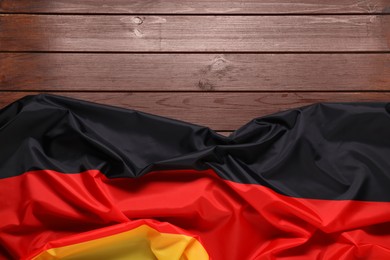 Photo of Flag of Germany on wooden background, top view. Space for text