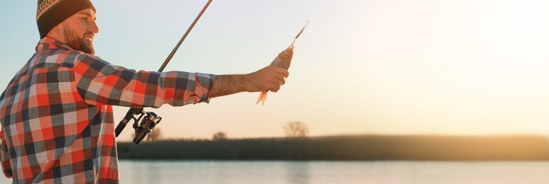 Image of Fisherman with rod and catch at riverside, space for text. Banner design