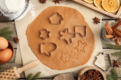 Flat lay composition with dough and cookie cutters on wooden table. Christmas biscuits