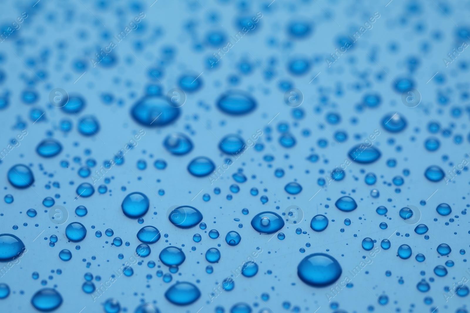 Photo of Water drops on blue background, closeup view