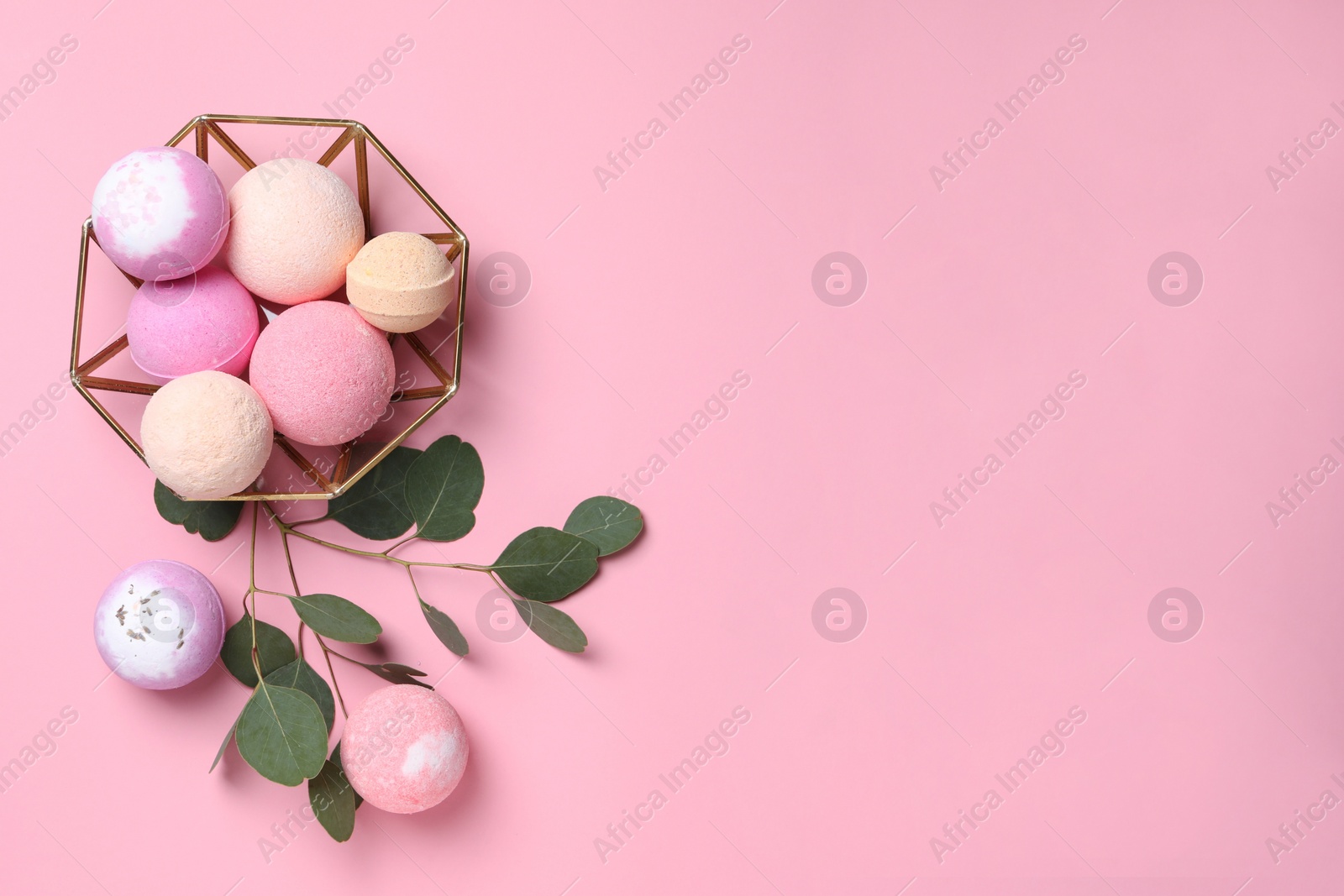 Photo of Bowl with bath bombs and eucalyptus leaves on pink background, flat lay. Space for text