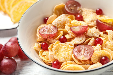 Corn flakes with berries on table, closeup. Healthy breakfast