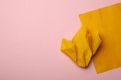 Photo of Orange reusable beeswax food wraps on pink background, top view. Space for text