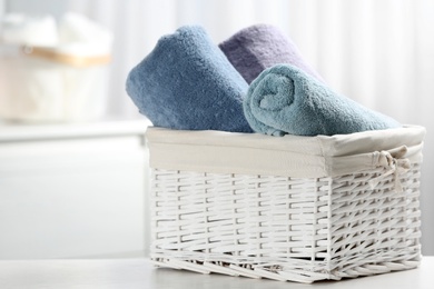 Basket of fresh towels on table. Space for text