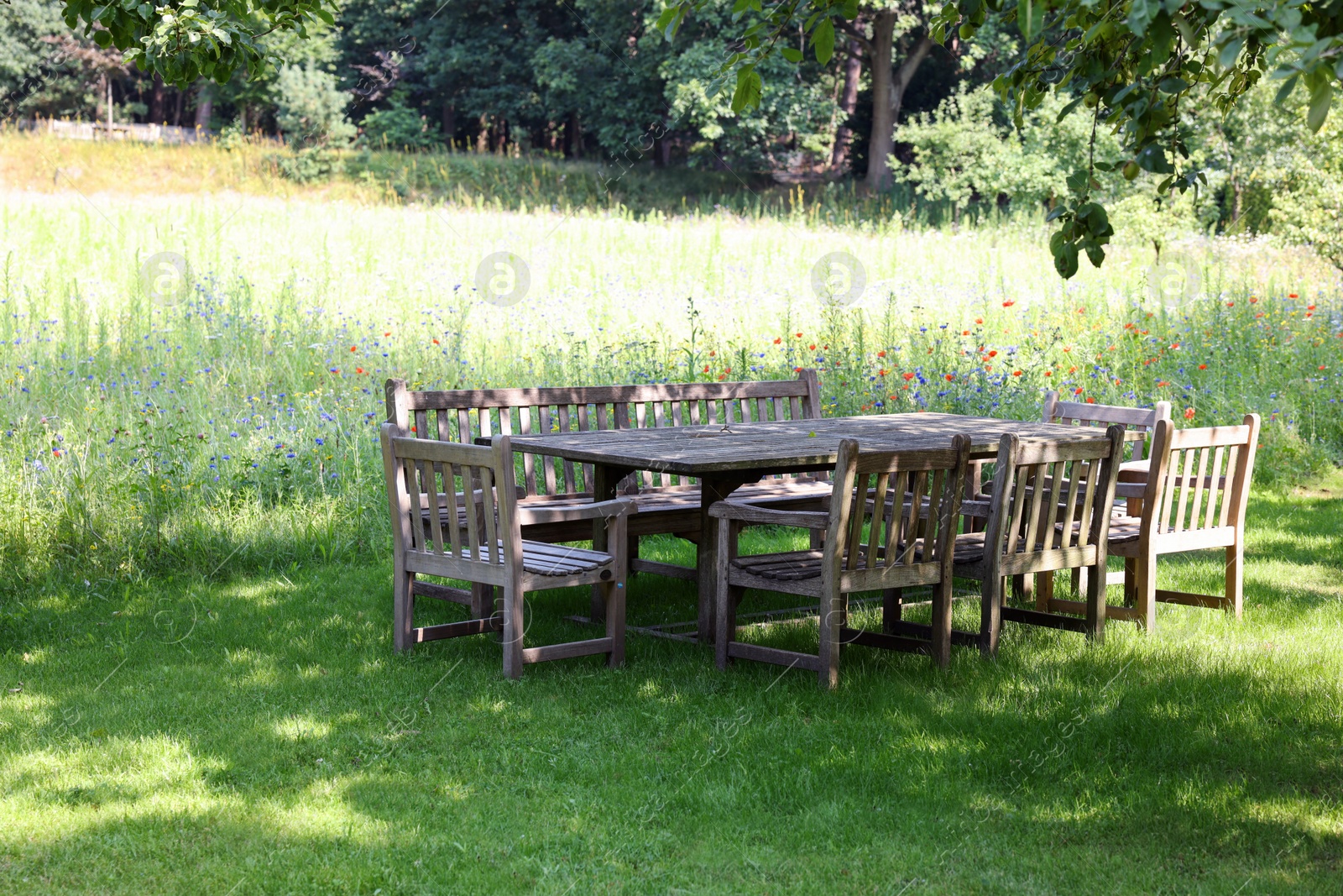 Photo of Empty wooden table with bench and chairs in garden