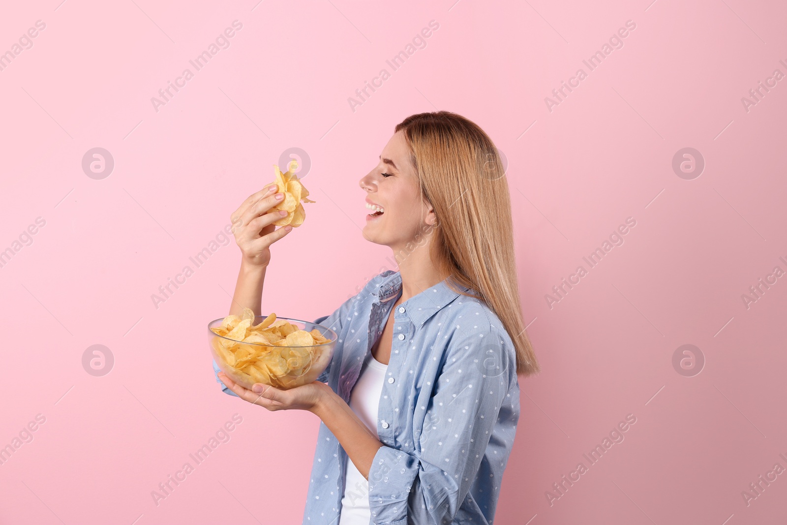 Photo of Woman eating potato chips on color background