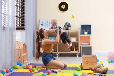 Teen nanny playing with cute little baby at home