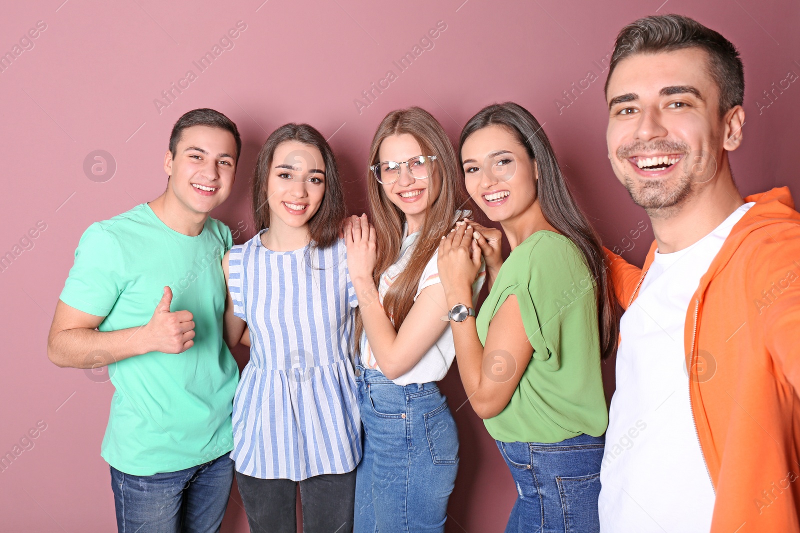 Photo of Young happy friends taking selfie against color background