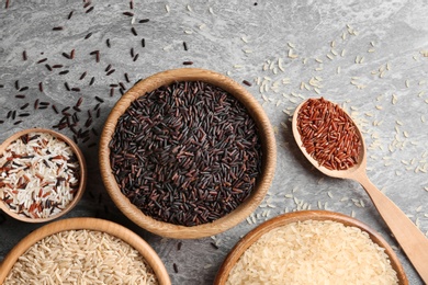 Flat lay composition with brown and other types of rice on grunge background