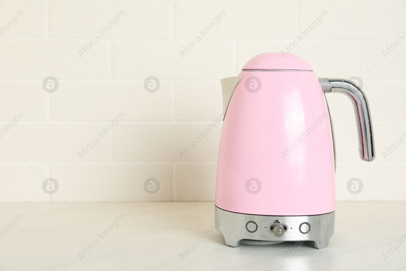 Photo of Modern electric kettle on counter in kitchen. Space for text