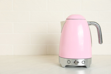 Modern electric kettle on counter in kitchen. Space for text