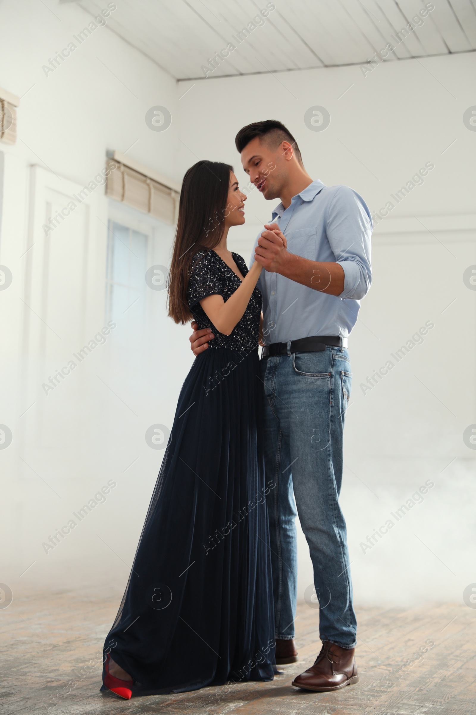 Photo of Lovely young couple dancing together in ballroom