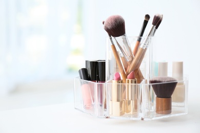 Photo of Organizer with makeup cosmetic products on table indoors. Space for text