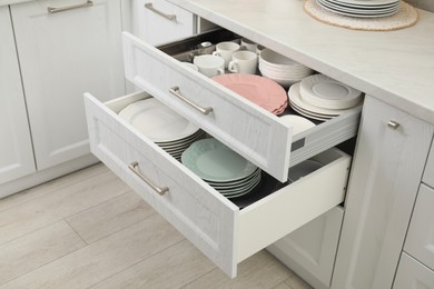Clean plates, bowls and cups in drawers indoors