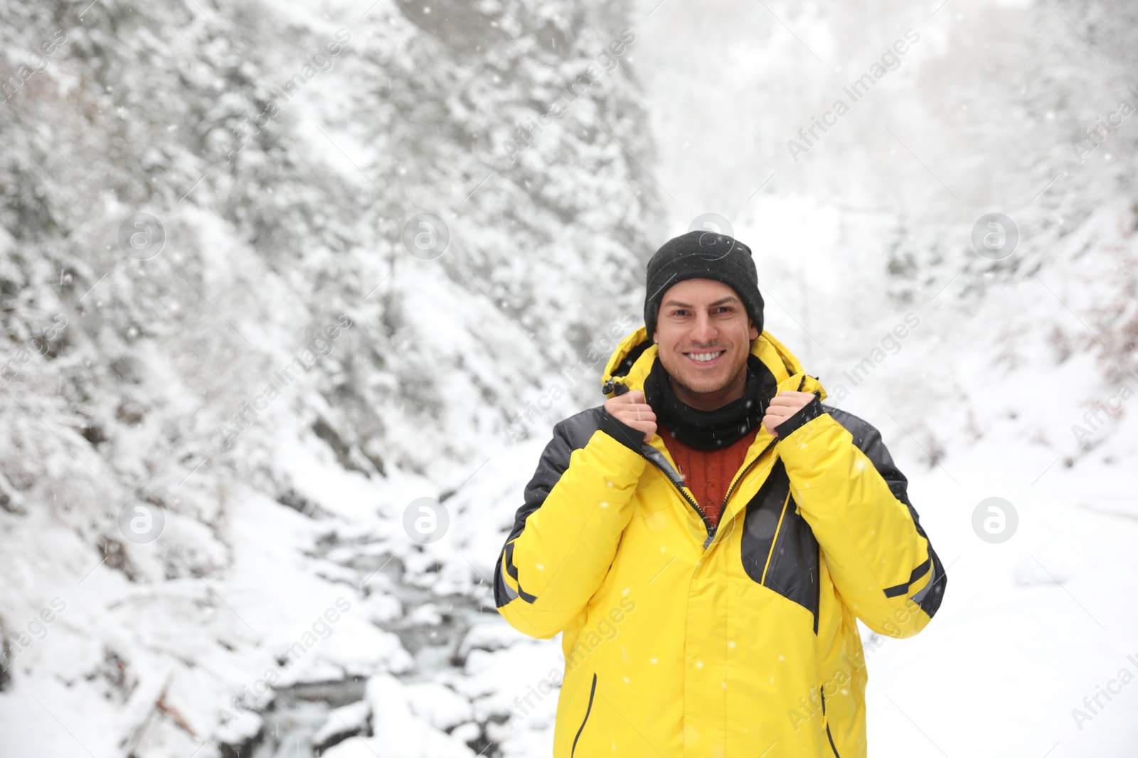 Photo of Handsome man wearing warm clothes outdoors on snowy day. Winter vacation