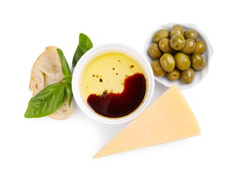 Photo of Bowl of organic balsamic vinegar with oil, basil, bread, cheese and olives isolated on white, top view