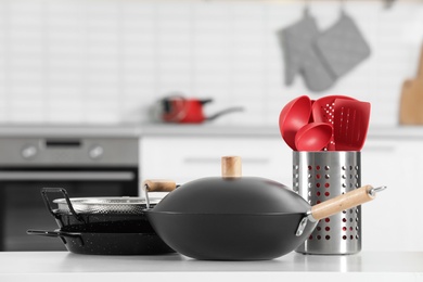 Photo of Set of clean cookware and utensils on table in kitchen. Space for text