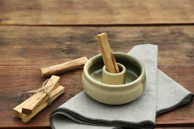 Palo Santo (holy wood) sticks and holder on wooden table