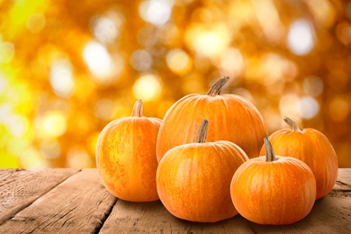 Fresh pumpkins on wooden table outdoors in autumn