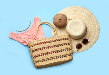 Flat lay composition with woman's straw bag on light blue background