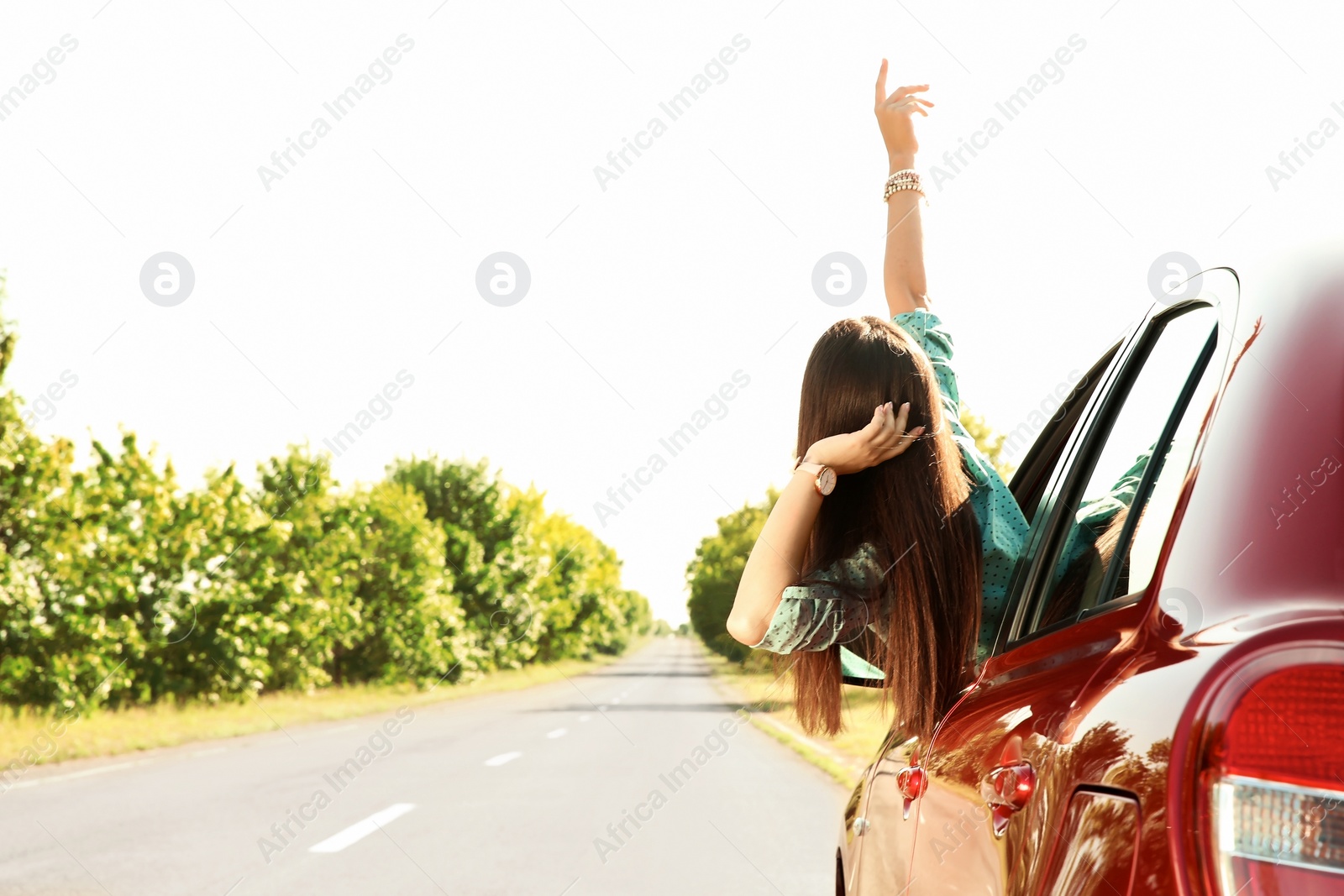 Photo of Young woman leaning out of car window