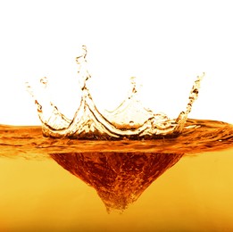 Golden oily liquid splash on white background