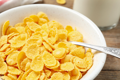 Photo of Tasty crispy corn flakes in bowl, closeup