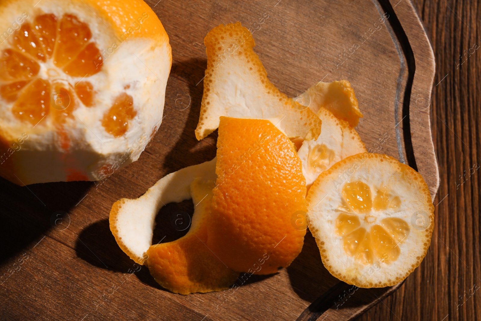 Photo of Juicy orange and peels on wooden table, top view