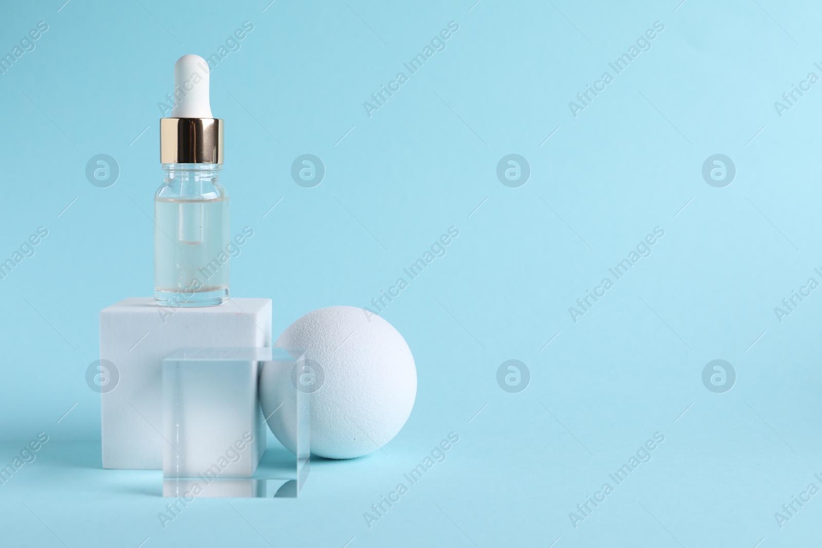 Photo of Stylish presentation of cosmetic serum on light blue background, space for text