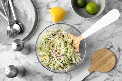 Photo of Flat lay composition with healthy cabbage salad on marble table in kitchen